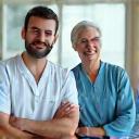 Δύο γιατροί, άνω των 40, συζητούν φιλικά με έναν ασθενή σε ένα μοντέρνο ιατρείο στην Αθήνα, απεικονίζοντας προληπτικό έλεγχο.